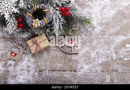 Weihnachtsdekoration mit festlichen Ornamenten auf rustikalem hölzernem Hintergrund und Schnee, rote Kugeln, Geschenkboxen mit Kopierraum, Vintage-Spielzeug von oben Stockfoto