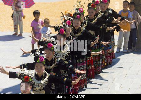 Xijiang, China, 15. September 2007: Linie der Miao-Frauen tanzen in vollen traditionellen Festivaljuwelen und farbenfrohen Kostümen in der ethnischen Minderheit Xijiang Stockfoto