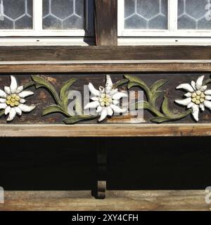 Edelweiss in die Fassade eines Schweizer Chalets geschnitzt Stockfoto