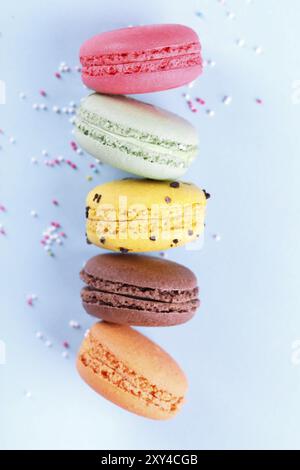 Bunte französische Macarons auf blauem Hintergrund traditionelles Dessert in Frankreich, vertikal Stockfoto