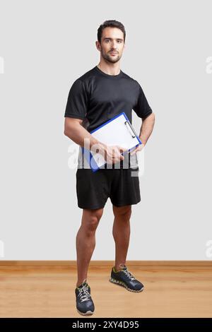 Personal Trainer, mit einem Pad in der Hand, in ein Fitness-Studio Stockfoto