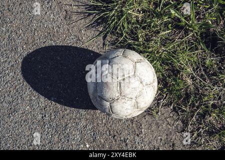 Gealterte weiße Fußball auf Asphalt Stockfoto