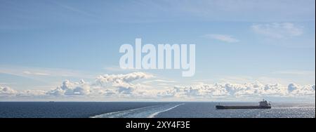 Ein Tankschiff, das an einem Sommertag an einer Fähre vorbeifährt Stockfoto