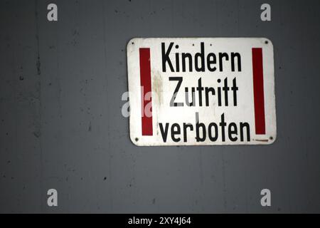 Schild am Eingang zu einem Parkplatz, Mutter muss zuerst das Auto holen und die Kinder steigen dann auf die Straße vor dem Parkplatz??? Stockfoto