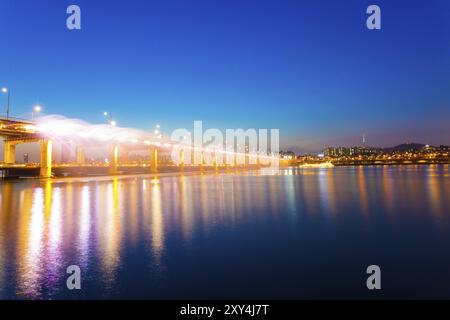 Wasser sprüht von der Seite der Banpo Bridge in den Han River während der Mondschein-Regenbogenbrunnen-Lichtshow in der Dämmerung in einer klaren Nacht in Seoul, Sout Stockfoto