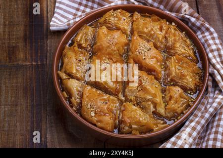 Hausgemachte Baklava mit Nüssen und Honigsirup auf alten rustikalen Holztisch Stockfoto