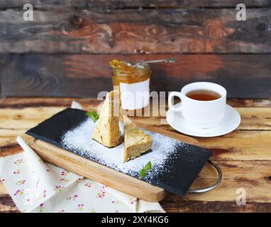 Traditionelle ungarische Esterhazy-Kuchen mit Tee und Marmelade auf einem hölzernen Hintergrund Stockfoto