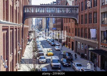 City Street in Chelsea mit gelbem Taxi und Lieferwagen, Luftaufnahme vom High Line Rooftop Park, Brücke zwischen zwei Bürogebäuden, Neu Stockfoto