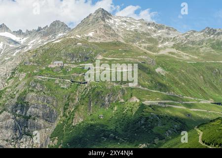 Blick auf die Furka Pass Straße Alpenpass mit engen Kurven Haarnadelkurven auf steilem Berghang über Baumgrenze im Sommer, Mittelpass Gipfel Furka Stockfoto