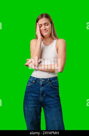 Eine Junge Frau Mit Jeans, Die Gegen Green Screen Weint Stockfoto