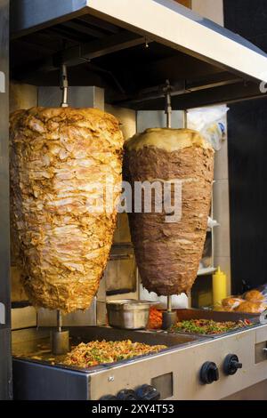 Ein Paar rotierender Hähnchen- und Lammfleisch, gegrillt und bereit zum Servieren in einem typischen Sandwich aus dem Nahen Osten Stockfoto