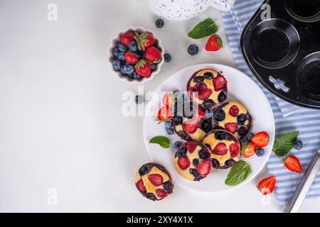 Portionierte gemischte Beerenblätter Pan Baked Pancakes, einfaches Rezept in Muffindosen. Mit frischer Heidelbeere und Erdbeere, Kopierraum Stockfoto
