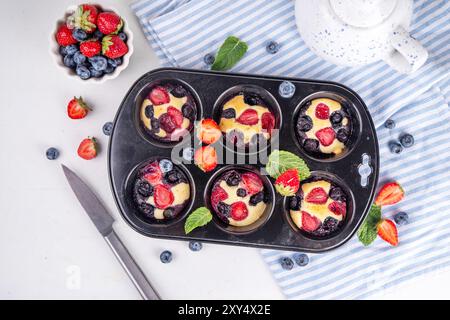 Portionierte gemischte Beerenblätter Pan Baked Pancakes, einfaches Rezept in Muffindosen. Mit frischer Heidelbeere und Erdbeere, Kopierraum Stockfoto
