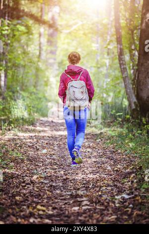 Junge Frau geht im Frühling durch den Wald Stockfoto