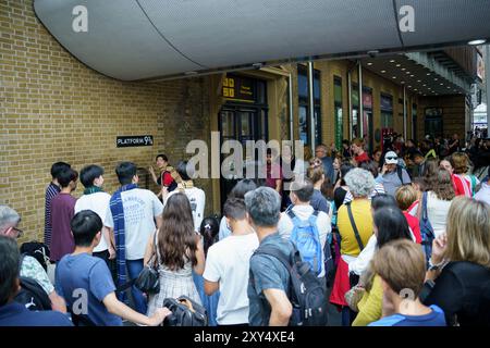 London, UK, 20. juli 2024. Japaner geben vor, einen Zauberstab in Bahnsteig 9 3-4 am Bahnhof King's Cross zu halten Stockfoto