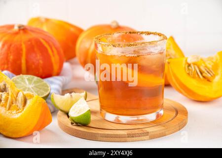 Thanksgiving Margarita, Süßer Kürbis Sträucher Cocktail, Alkohol leckeres Herbstgetränk auf weißem Hintergrund mit Scheiben Kürbisse, Kopierraum Stockfoto