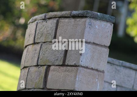 Gekrümmte Ziegelwand im Garten Stockfoto