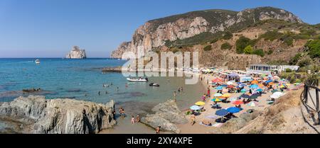 Masua, Italien - 23. August 2023: Panoramablick auf den Strand Masua im Süden der Insel Sardinien, Italien, mit den Überresten eines alten Lagerhauses, das in der genutzt wurde Stockfoto