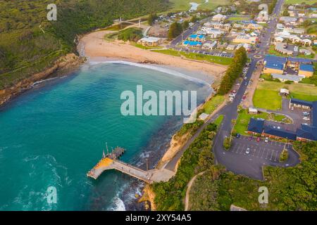 Aus der Vogelperspektive auf ein kleines Küstenstädtchen hinter einem Sandstrand und einer geschützten Bucht von Port Campbell an der Great Ocean Road in Victoria Australien. Stockfoto