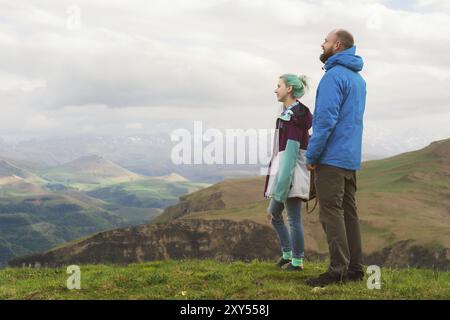 Ein Paar Hipster-Touristen steht nebeneinander in den Bergen vor der Kulisse des Hochplateaus aus Tälern und Himmel. Die Erholung findet man in den mountai Stockfoto