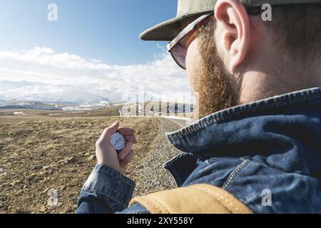 Nahaufnahme Hipster Mann mit einem Kompass auf einem verschneiten Berg Stockfoto