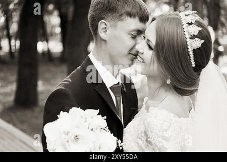 Porträt eines frisch vermählten Paares auf einem Hochzeitsspaziergang. Das Konzept eines glücklichen jungen Paares. Hochzeit in Schwarz- und Weißtönen Stockfoto