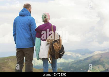 Ein Paar Hipster-Touristen steht nebeneinander in den Bergen vor der Kulisse des Hochplateaus aus Tälern und Himmel. Die Erholung findet man in den mountai Stockfoto