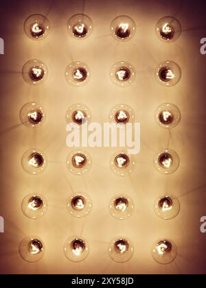 Gruppe von leuchtenden Glühlampen auf gelber Rückseite Stockfoto