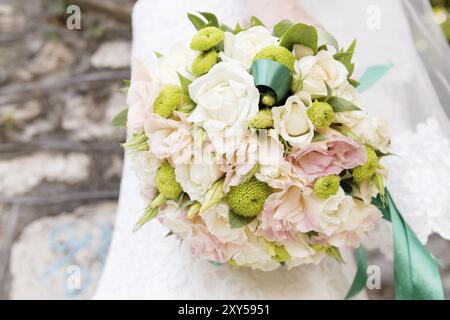 Hochzeitsstrauß auf einem Hochzeitskleid. Nahaufnahme Stockfoto