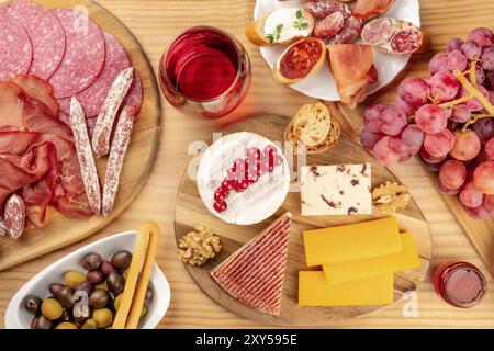 Charcuterie Verkostung. Ein Foto von vielen verschiedenen Wurst und Schinken, Aufschnitt, und eine Käseplatte, geschossen von oben auf eine rustikale Hintergrund mit einem gl Stockfoto
