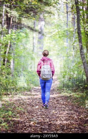 Junge Frau geht im Frühling durch den Wald Stockfoto