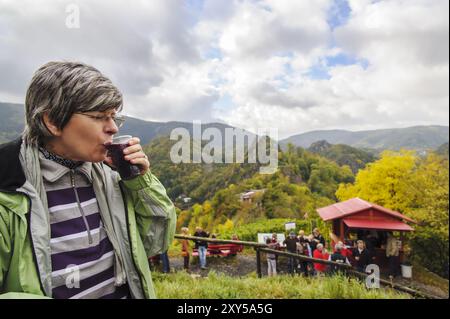 Eine Frau sitzt über dem Rotweinwanderweg und genießt eine Tasse Federroter Stockfoto