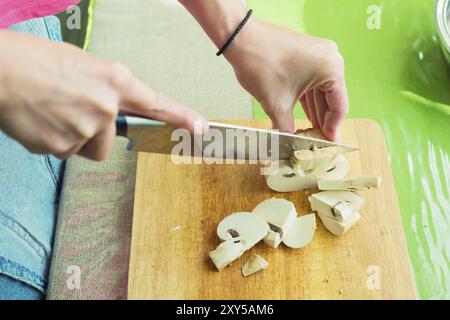 Kochen Von Pilzen. Schneiden. Weibliche Hände auf einem Schneidebrett in große Holzpilze geschnitten. Das Konzept des Kochens zu Hause. Das Konzept der Heilung Stockfoto
