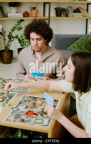 Junger Mann und Frau, die modernes Brettspiel spielen Stockfoto