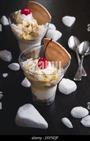 Durian-Eis mit Kirschen und Waffel auf schwarzem Holz Hintergrund Stockfoto