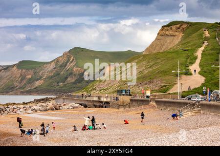 Großbritannien England, Dorset, Bridport, West Bay, Besucher am Strand unterhalb des Küstenpfads, der über die Klippen der Jurassic Coast steigt Stockfoto