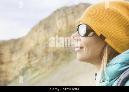 Nahaufnahme Porträt eines Mädchens Reisenden in einem Hut und kletternde Sonnenbrille. Happy Girl auf dem Hintergrund der Felsen Stockfoto