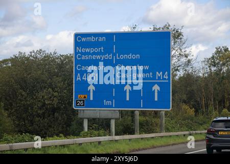 Eine Straßenmarkierungstafel für die Newport Cwmbran biegt an der Anschlussstelle 26 der Autobahn M4 in Wales mit zweisprachiger Beschilderung ab. Stockfoto