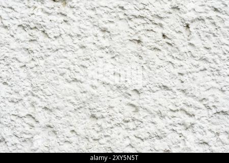 Nahaufnahme Tiefe Textur von weiß lackiertem porösem Stein auf der Fassade des Gebäudes. Gesteinte Hintergrundstruktur der Wand Stockfoto