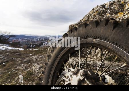 Rad mit Speichen und Bremsscheibe plus Enduro Motorradkette. Nahaufnahme im Hintergrund einer Landschaft Stockfoto