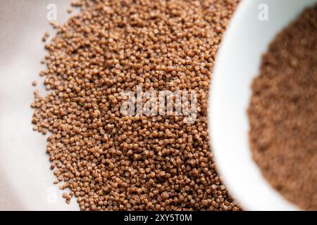 Herstellung von trockenem Buchweizen-Couscous. Nahrhafte Rohzutat in grauer Küchenschüssel und weißer Tasse zum Dämpfen aus nächster Nähe Stockfoto