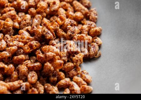 Schokolade knuspriger Reis Frühstück Müsliflocken verstreut auf einem schwarzen Teller Nahaufnahme Stockfoto