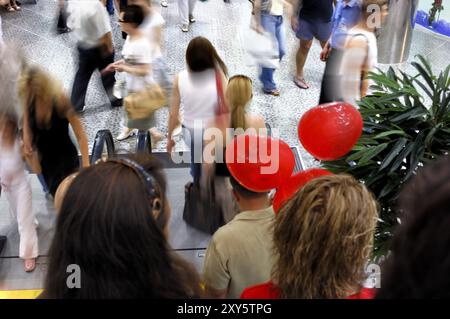 Menschen, die in einem Einkaufszentrum mit Bewegungsunschärfe laufen, verbessern die Dynamik der Szene Weihnachtseinkäufe Stockfoto