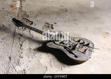 Verbrannte Gitarre auf dem Boden eines verlassenen Hauses in Magdeburg Stockfoto