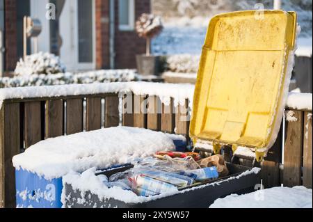 Geöffneter gelber Behälter vor einem Wohngebäude Stockfoto