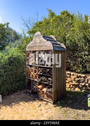 Ein Insektenhotel in einem Garten, in dem einheimische, wandernde und einsame Insekten Unterschlupf und Nistplätze bieten Stockfoto