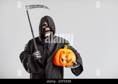 Porträt Des Sensenmanns Mit Scythe, Der Kürbis Auf Grauem Hintergrund Hält Stockfoto