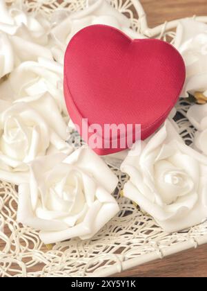 Rote, herzförmige Geschenkbox mit weißen Rosen, Vintage Farbe getönt Stockfoto