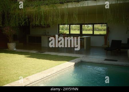 Tabanan, Bali, Indonesien - 26. August 2024: Luxusvilla im industriellen Stil mit offener Küche, privatem Pool und Garteneinrichtung Stockfoto