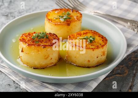 Fondant Potatoes sind ein traditionelles französisches Kartoffelgericht, bei dem Sie Kartoffeln pfannen und anschließend in Butter, Knoblauch, Kräutern und Brühe auf der pla dünsten Stockfoto